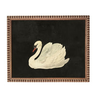 A painting of a swan in a black background, framed in an ornate brown frame.