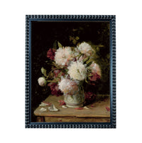 A framed painting depicting a vase filled with white and pink flowers, placed on a wooden table.