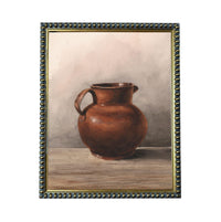 A brown ceramic pitcher with a handle, sitting on a wooden surface.