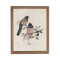A framed painting depicting two colorful birds perched on a branch with leaves and flowers.
