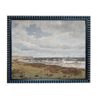 The image is a framed painting depicting a beach scene with waves crashing against the shore and a cloudy sky above.