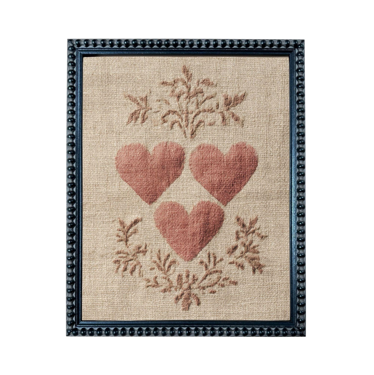 a framed piece of artwork with a beige background and a floral design. The artwork is framed in a black frame with a decorative border. The artwork displays three red hearts arranged in a circular pattern, surrounded by a floral design.