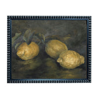 A framed painting depicting three lemons on a dark background.