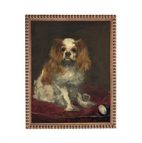 A portrait of a Cavalier King Charles Spaniel dog sitting on a red cushion.