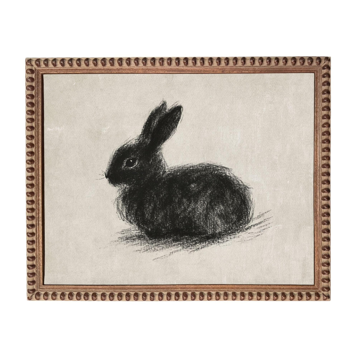 A black rabbit sitting on a beige background, framed in a brown frame.